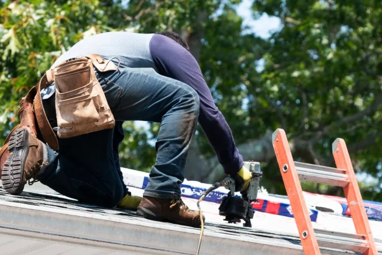 Technician installing or repairing roof shingles on residential home exterior