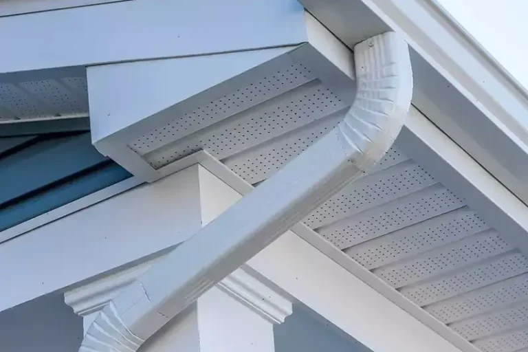 Residential gutter installation system showing metal gutters and downspout components mounted on house exterior