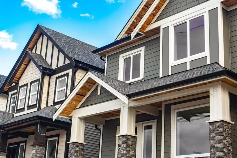 Modern two-story residential home with gray and white siding, gabled roof, and professional exterior finish